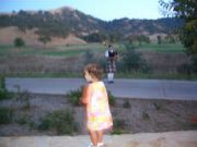 Mike's grandaughter, Maia listening to the bagpiper call in the golfers